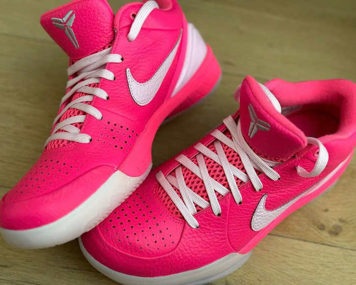 Side view of pink and white Nike Kobe sneakers.